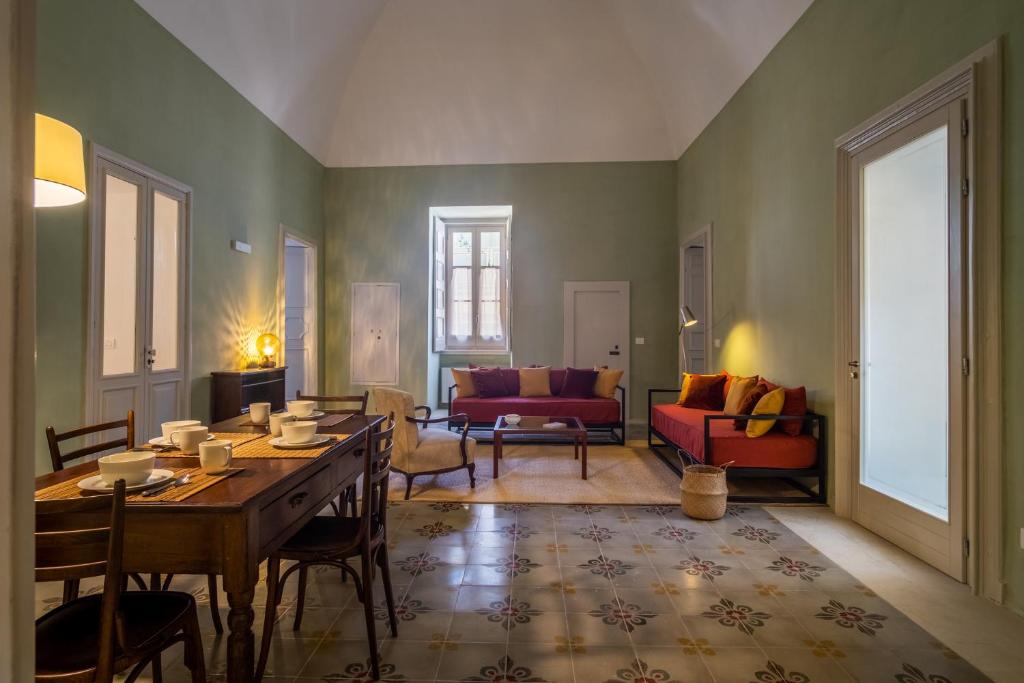 马利耶Palazzo Garzia Residence - Dimora storica的客厅配有桌子和沙发