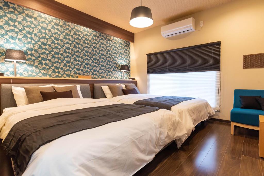 大阪Bijou Suites Miyabi的一间卧室配有一张大床和一张蓝色椅子