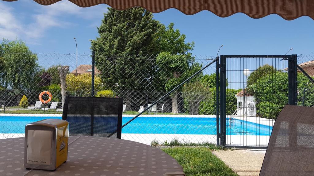Pedrosillo el RaloHostal Restaurante Carolina的背景中带游泳池的围栏