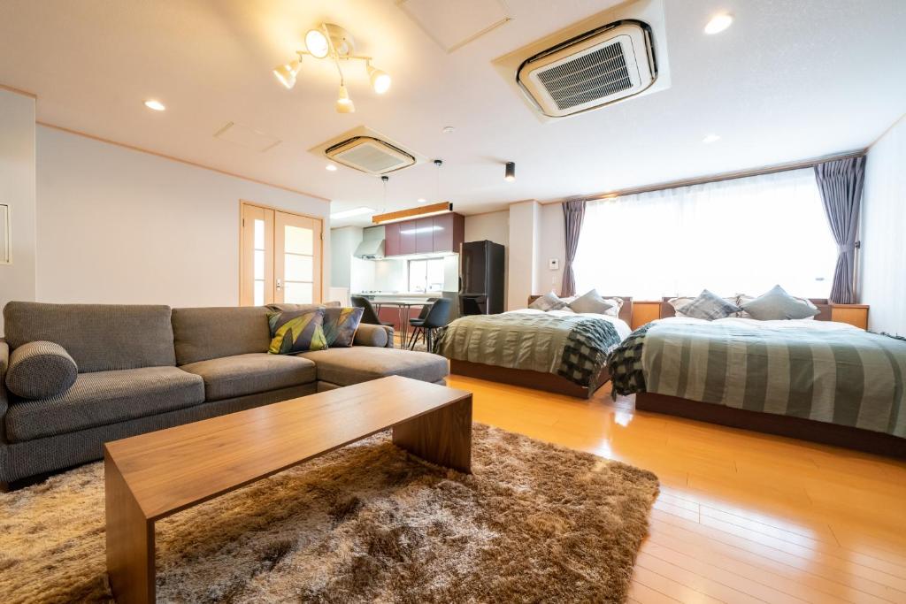 神户HOTEL er.的客厅配有沙发和1张床