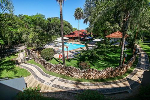 博尼图Hotel Pousada Bonsai的一个带游泳池和岩石墙的度假胜地