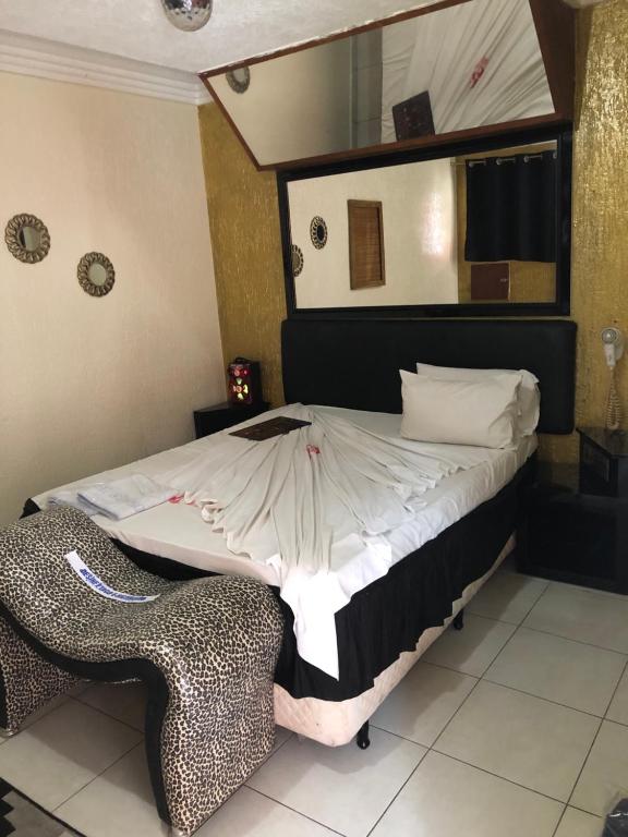 圣保罗HOTEL MEDIEVAL的一间卧室配有一张带镜子和椅子的床