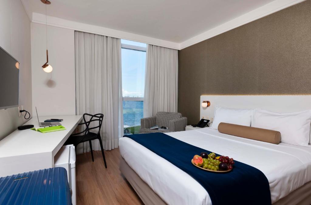 维多利亚维多利亚码头酒店的酒店客房,配有一张床铺,上面放着一碗水果