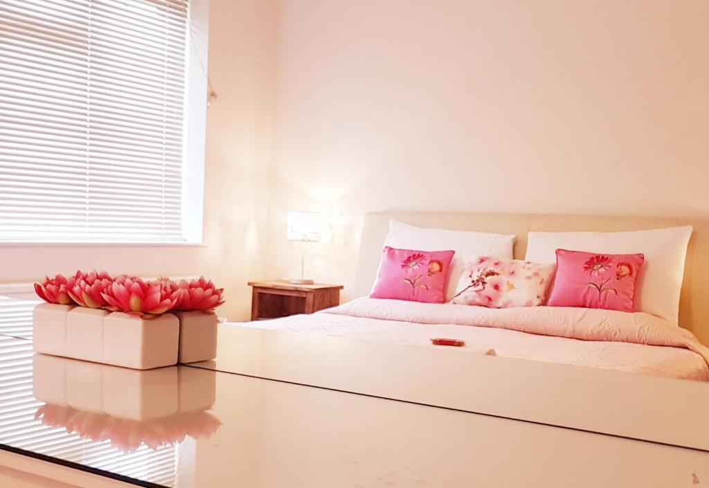 诺丁汉Faraday Place的白色卧室配有粉红色枕头和床
