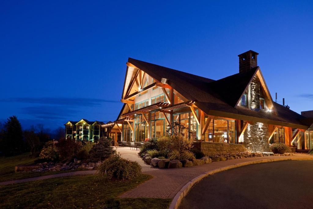 普莱西德湖普莱西德湖皇冠假日酒店的一座大型的木制建筑,晚上有灯