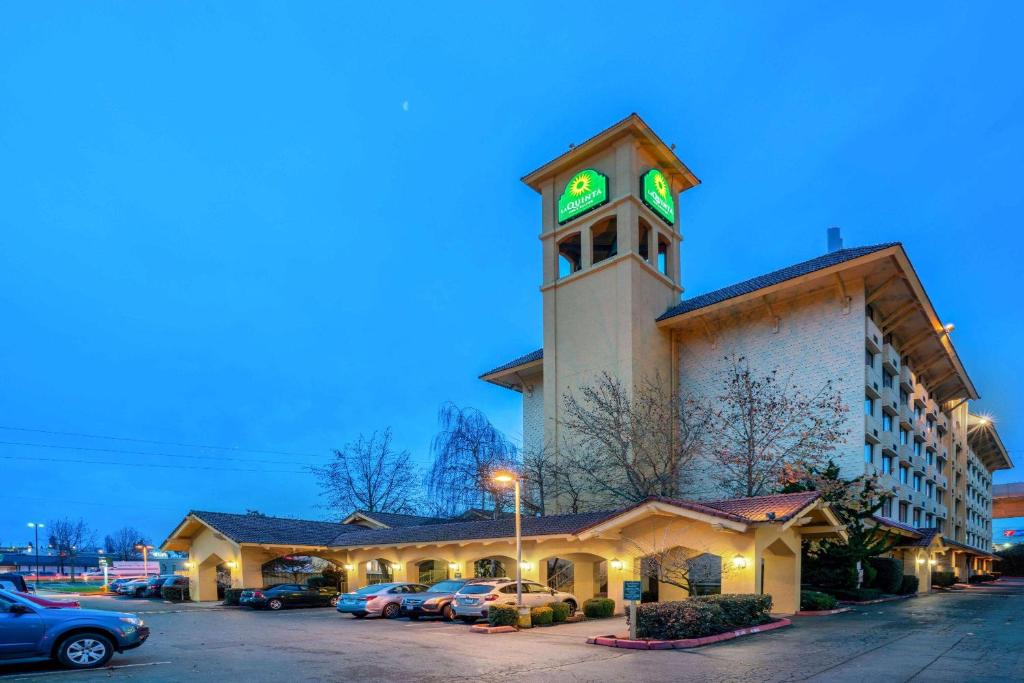 西塔科拉群塔西雅图西塔机场酒店&套房的一座带钟楼和停车场的建筑