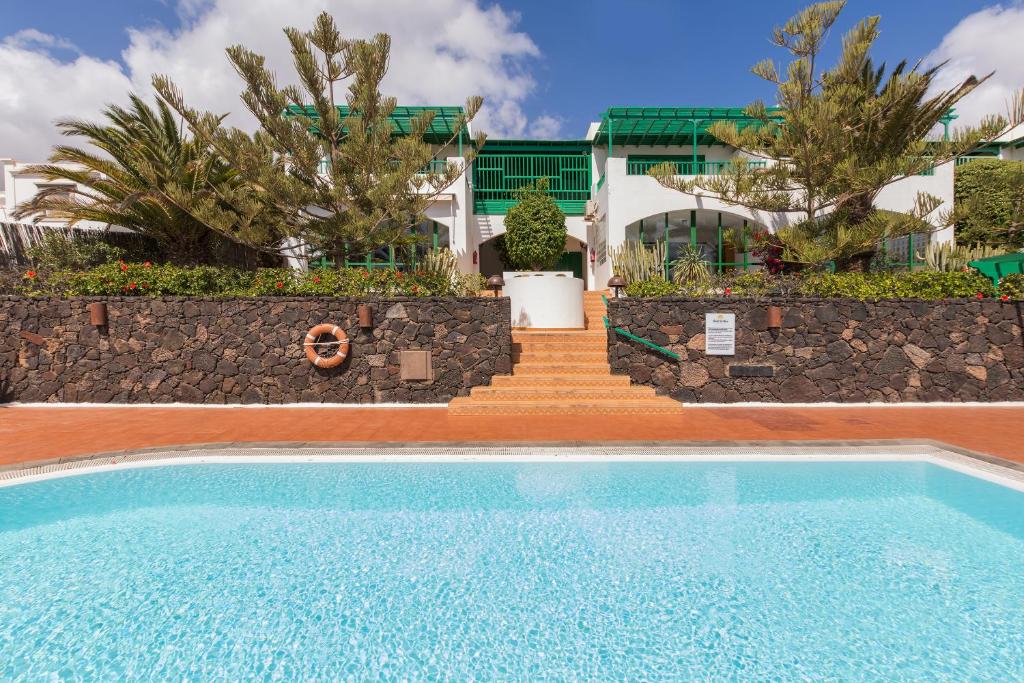 科斯塔特吉塞Conylanza Golf y Mar Suites的一座带楼梯的房屋前的游泳池
