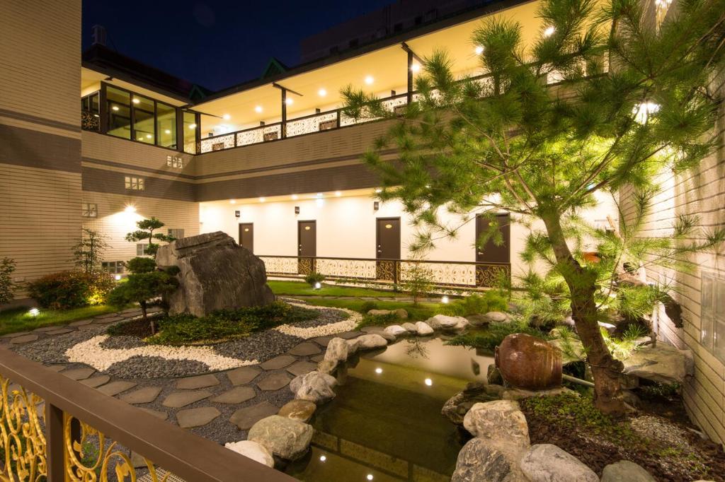 花莲市东大门精致旅店 的一座花园,在一座建筑前设有一个池塘
