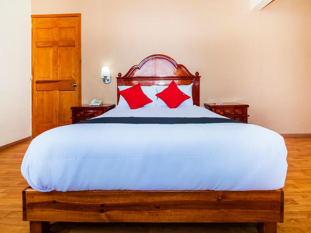 底拉斯卡拉Hotel De La Loma的卧室配有带红色枕头的大型白色床