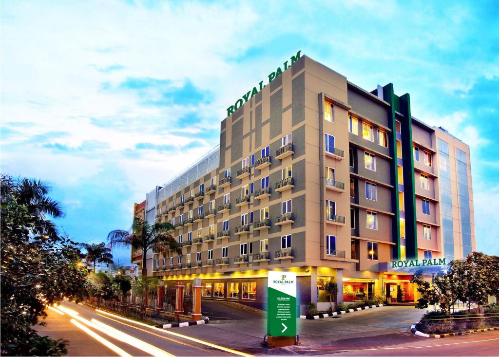 雅加达Royal Palm Hotel & Conference Center Cengkareng的夜间城市街道上的酒店大楼