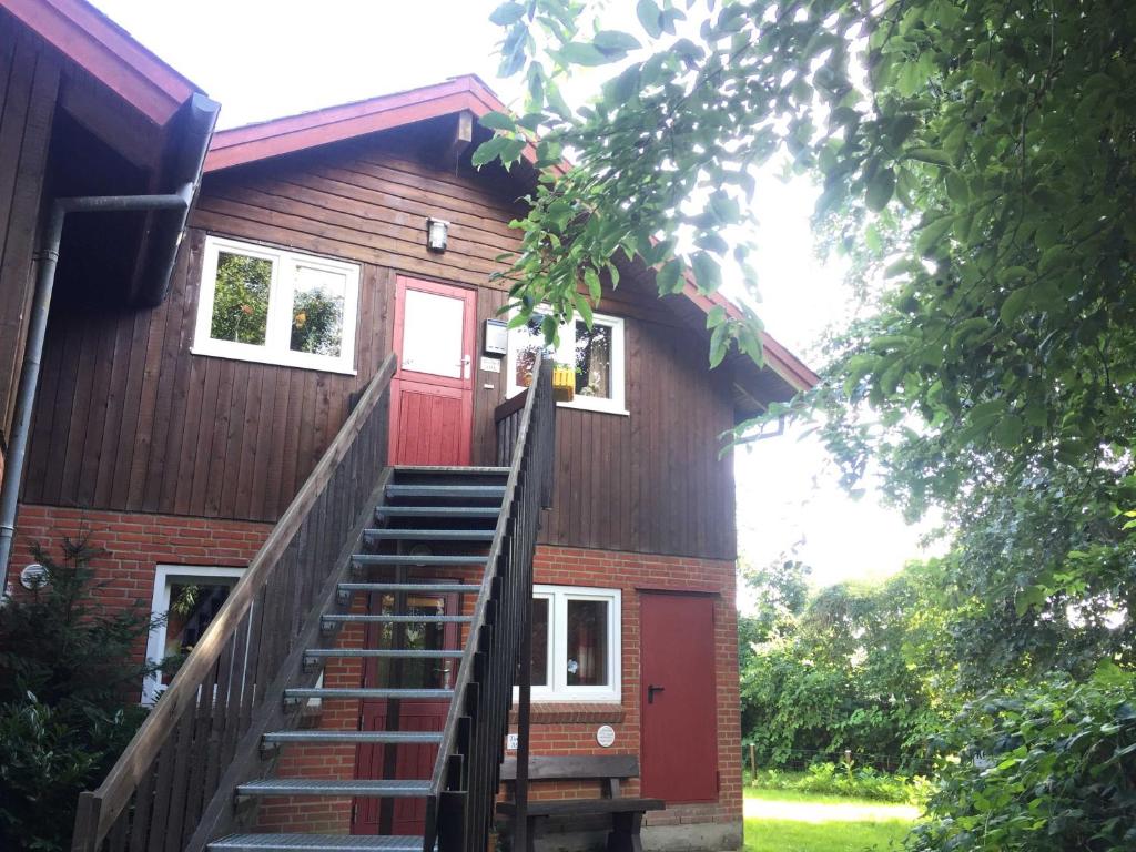 格吕克斯堡Ferienwohnung Torge的通往红色门的房子的楼梯