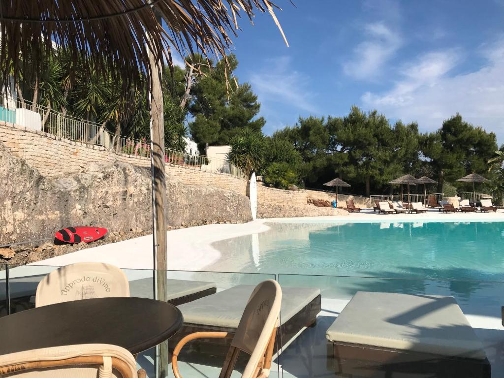 维耶斯泰Viestemare Resort & SPA的享有带椅子和桌子的游泳池的景色