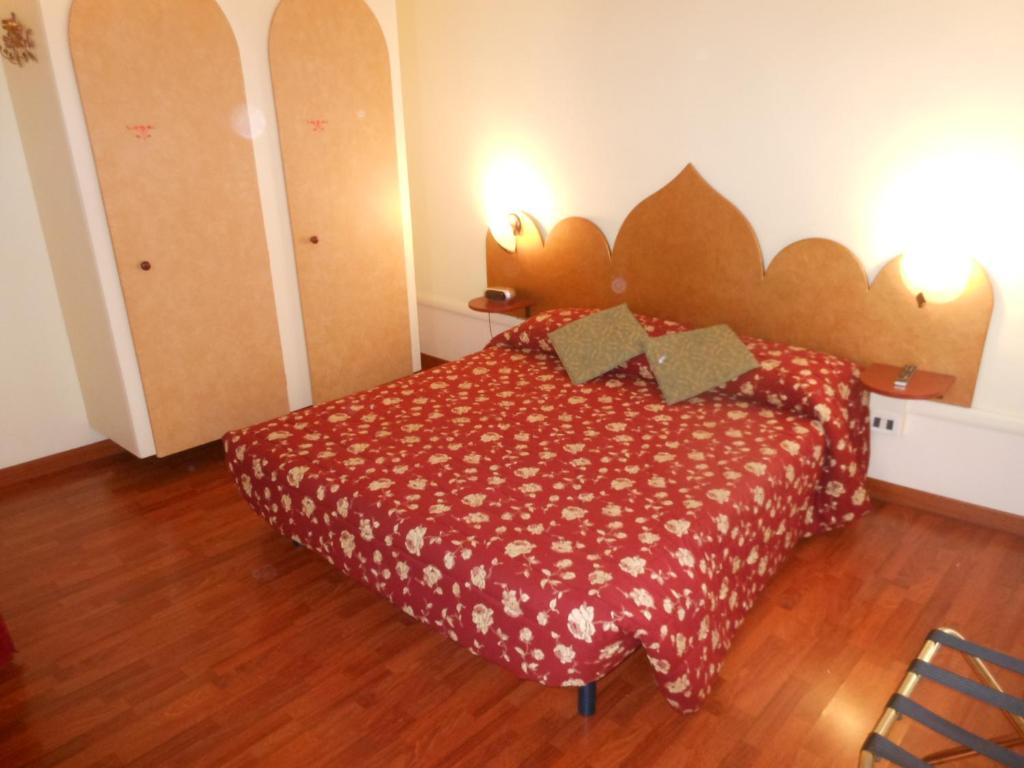 威尼斯卡德多赛酒店的一间卧室配有一张红色床罩的床