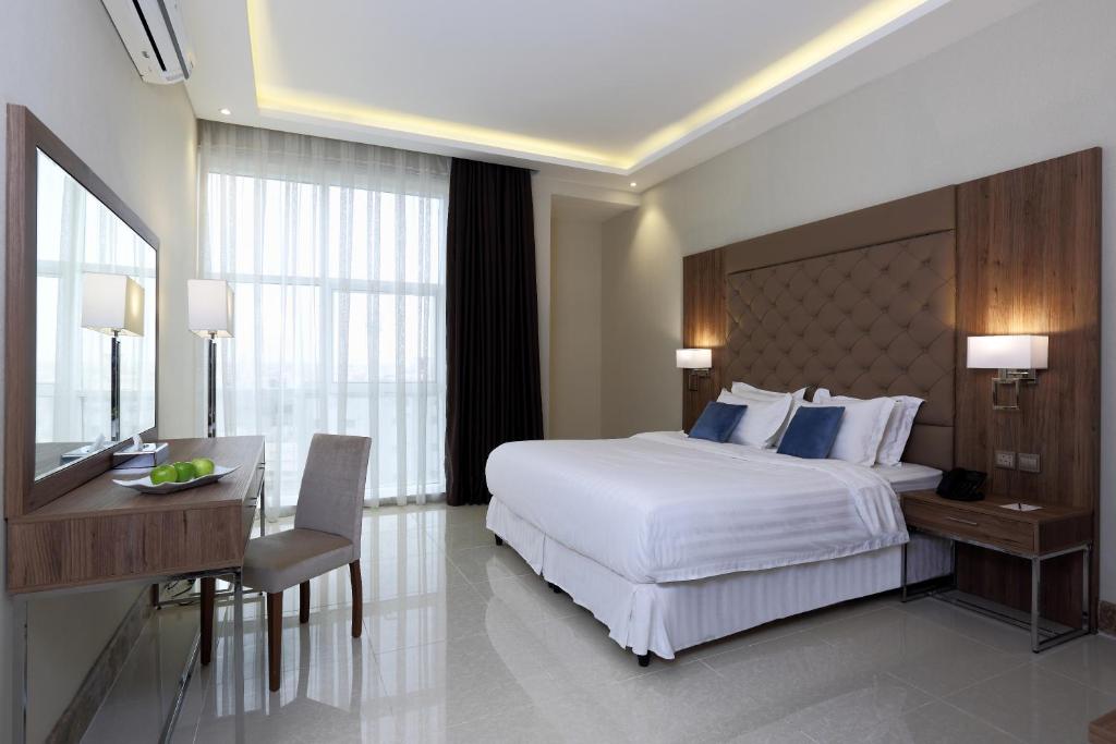 海米斯穆谢特فندق كود العربية Kud Al Arabya Apartment Hotel的卧室配有一张白色大床、一张书桌和一张书桌