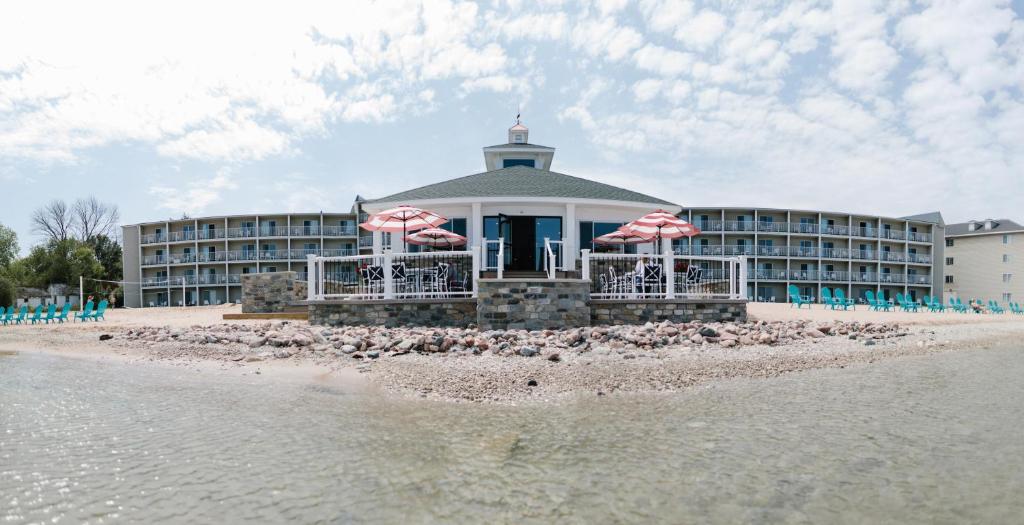 圣伊尼亚斯布雷克湖滨度假酒店的海滩上的酒店,配有椅子和遮阳伞