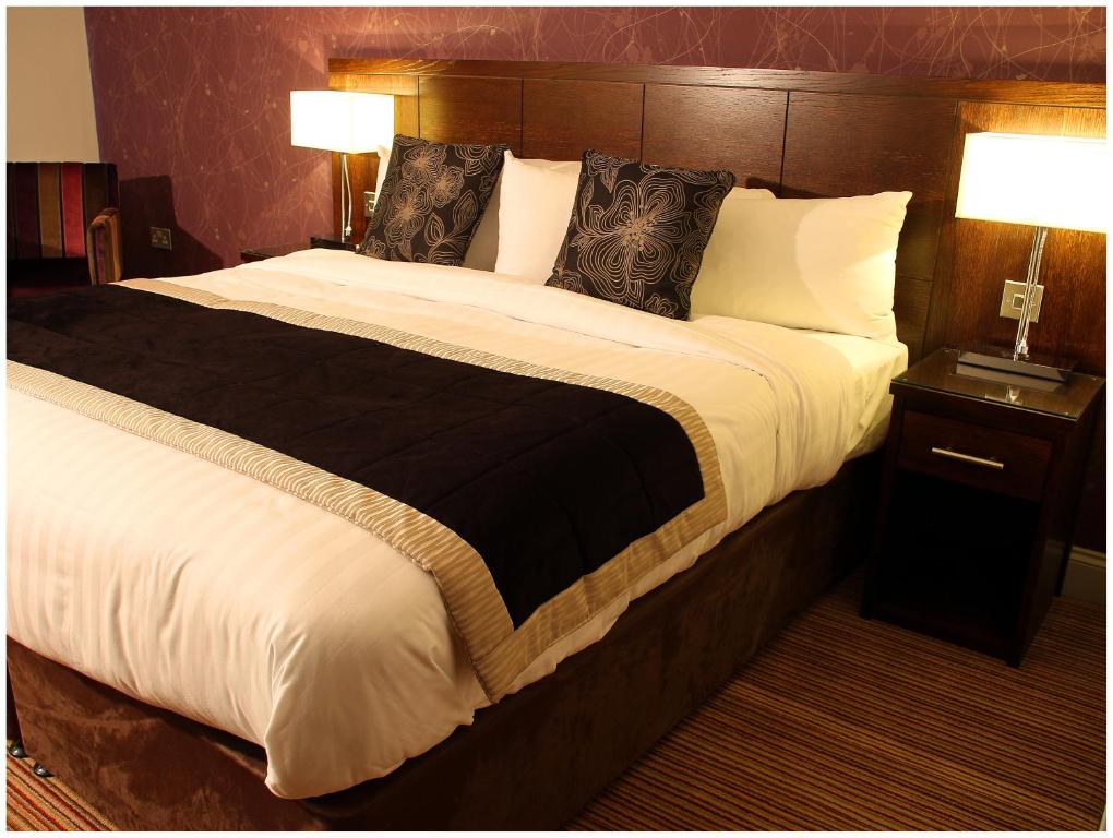 塔尔伯特港布兰科酒店的一张大床,位于酒店带两盏灯的房间