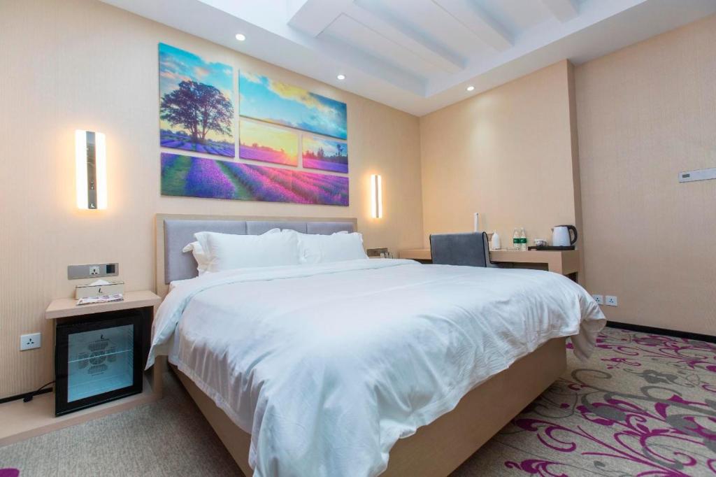 大连麗枫酒店·大连星海公园店的卧室配有一张大床,墙上挂有绘画作品