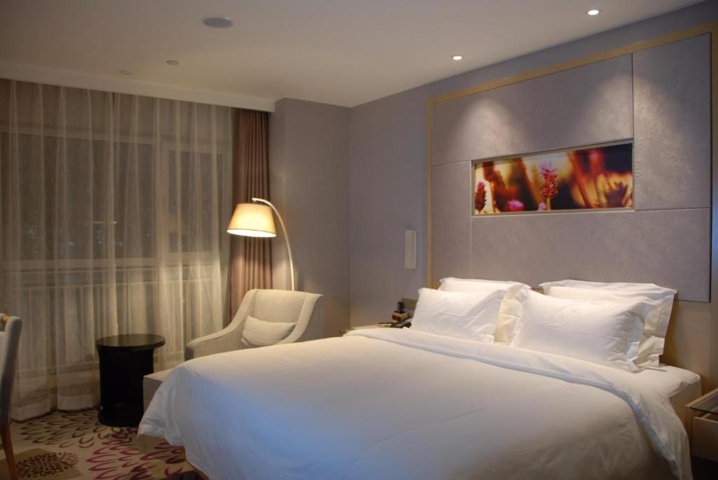 西安麗枫酒店·西安高新区西部大道阳光城的卧室配有一张白色大床和一把椅子