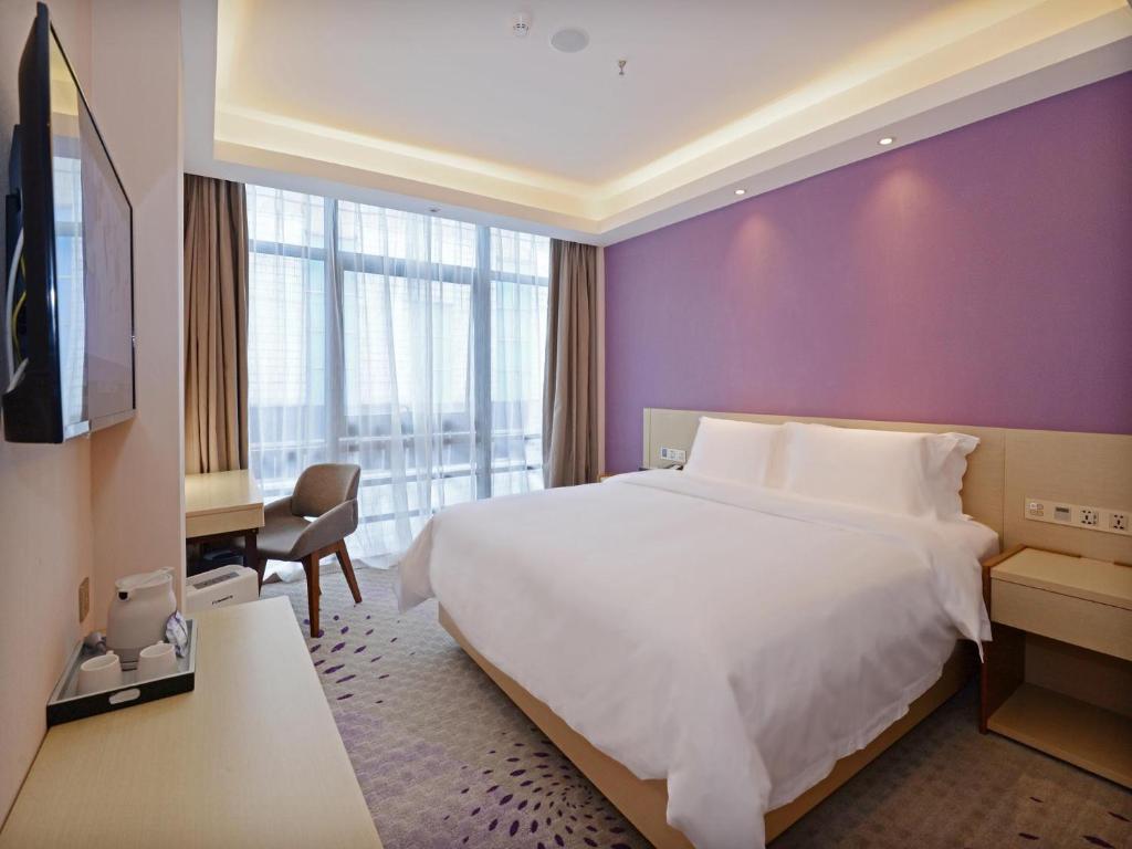 西安麗枫酒店·西安钟楼店的酒店客房设有一张白色的床和紫色的墙壁