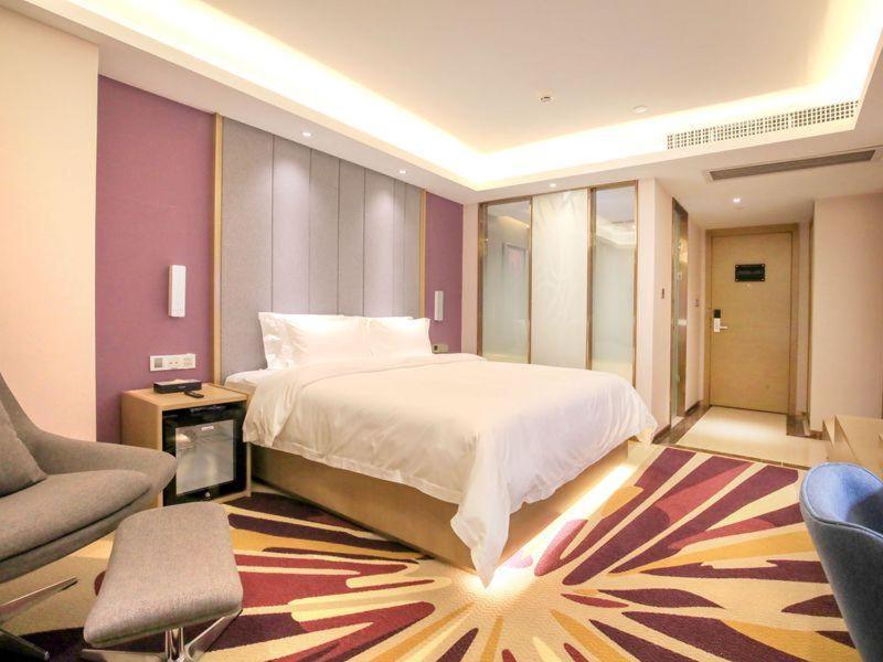 广州麗枫酒店·佛山碧江轻轨碧桂园总部店的一间卧室配有一张床、一张沙发和一把椅子
