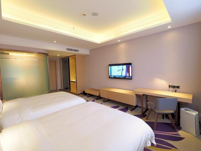 广州麗枫酒店·广州洛溪厦滘地铁站店的酒店客房配有一张床、一张书桌和一台电视。