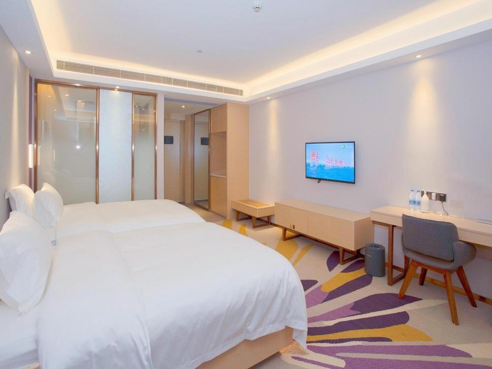 南京麗枫酒店·南京奥体南部岱山新城店的卧室配有白色的床、书桌和电脑