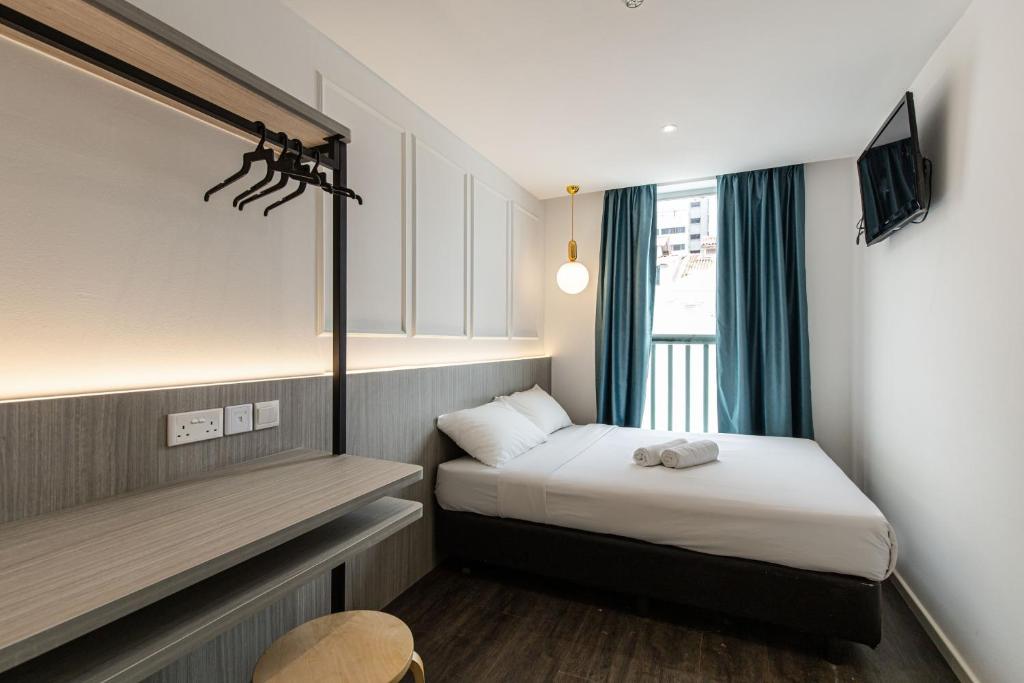 新加坡Philip Hotel的小房间设有两张床和窗户