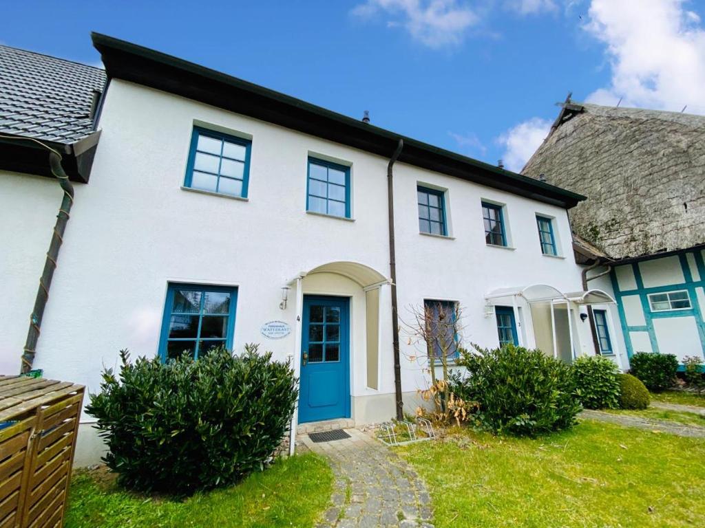 瓦尔内明德Ferienhaus Waterkant的白色的房子,有蓝色的门