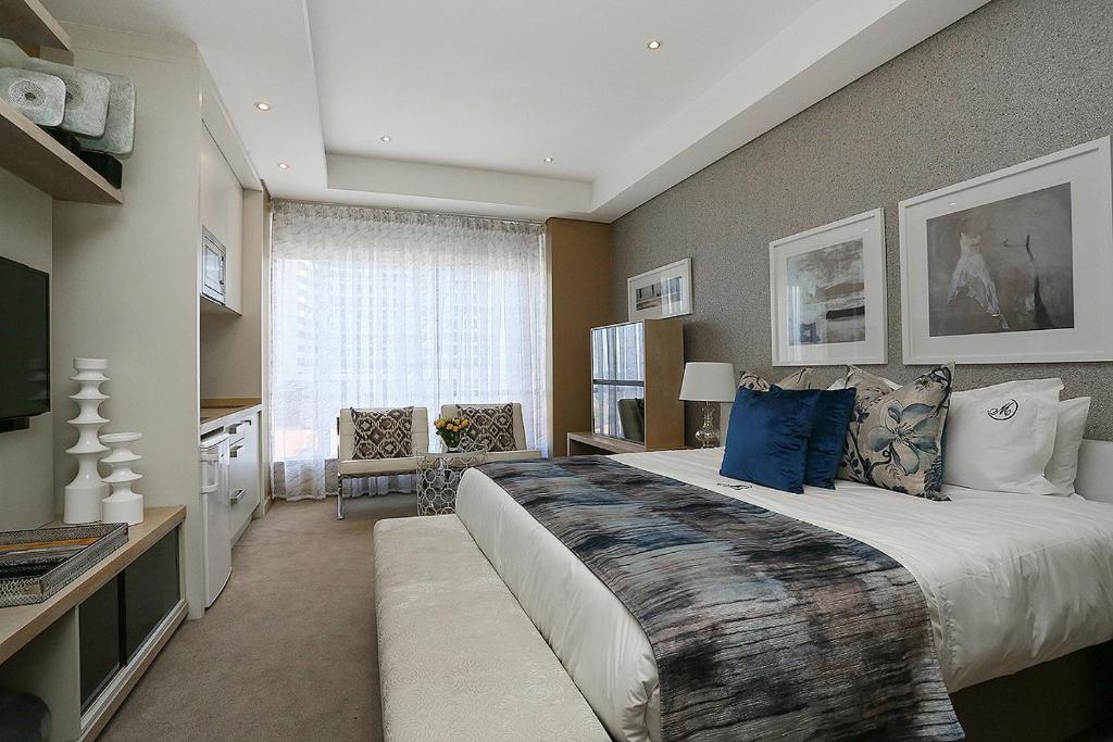 约翰内斯堡305 Sandton Skye的大卧室配有一张带蓝色枕头的大床