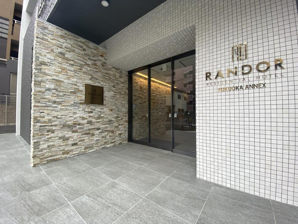 福冈Randor Residential Hotel Fukuoka Annex的建筑的大堂,有砖墙