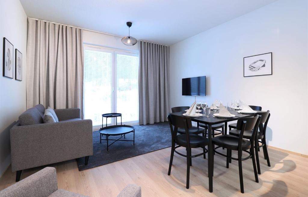 坦佩雷Forenom Aparthotel Tampere Kaleva的客厅设有餐桌和沙发
