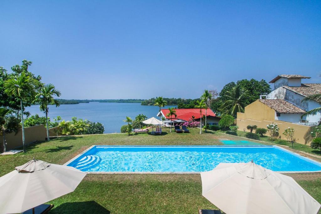 希克杜沃Kalla Bongo Lake Resort的游泳池的图片,带有遮阳伞