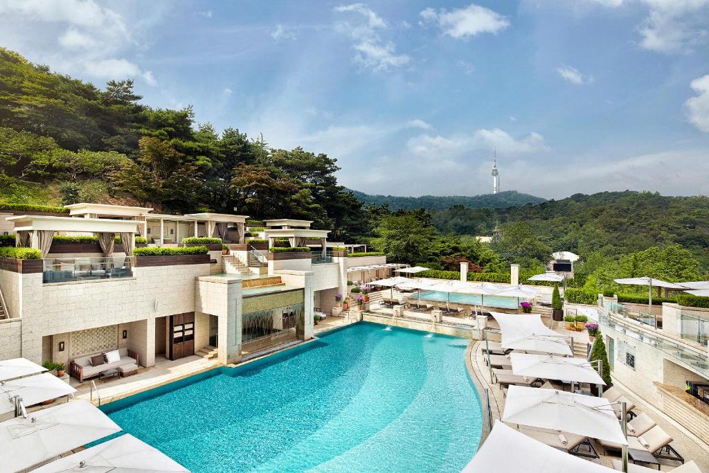 首尔首尔新罗酒店的一座带遮阳伞的建筑的顶部游泳池