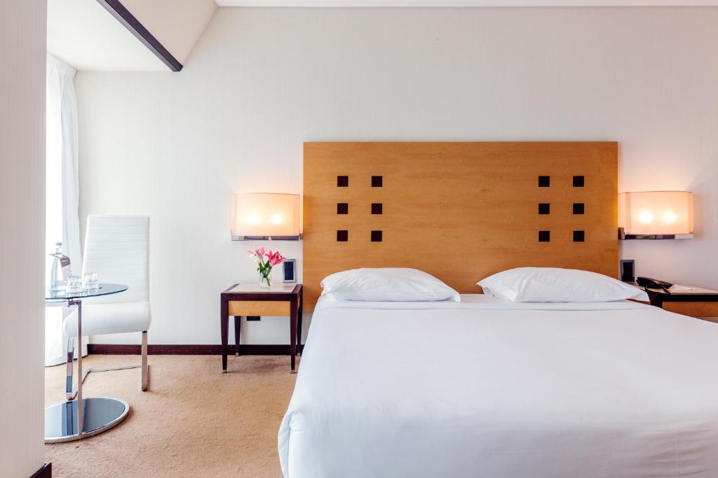 法蒂玛法蒂玛勒克斯酒店的卧室配有一张白色大床和一张书桌