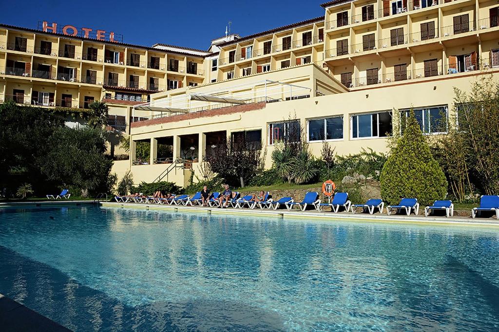 罗萨斯格蕾斯酒店的一座带椅子的游泳池和一座建筑的酒店