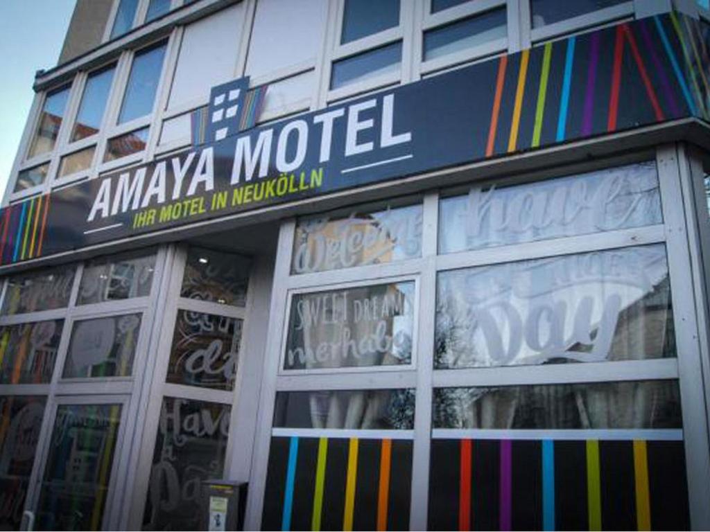 柏林Amaya Motel的建筑前有标志的商店