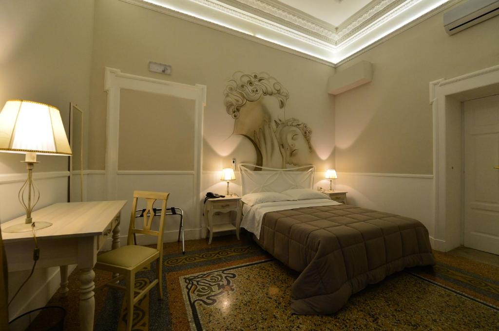 福贾凯沃尔伯爵住宿加早餐旅馆的卧室配有一张床铺,墙上挂着雕像