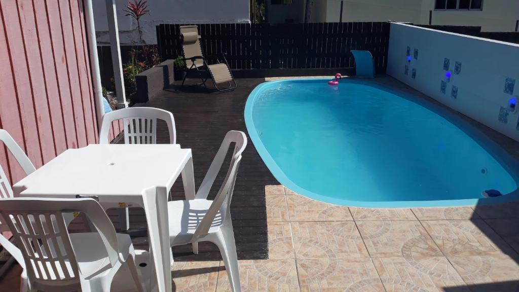 弗洛里亚诺波利斯Casa Ribeirao da Ilha的游泳池旁的桌椅