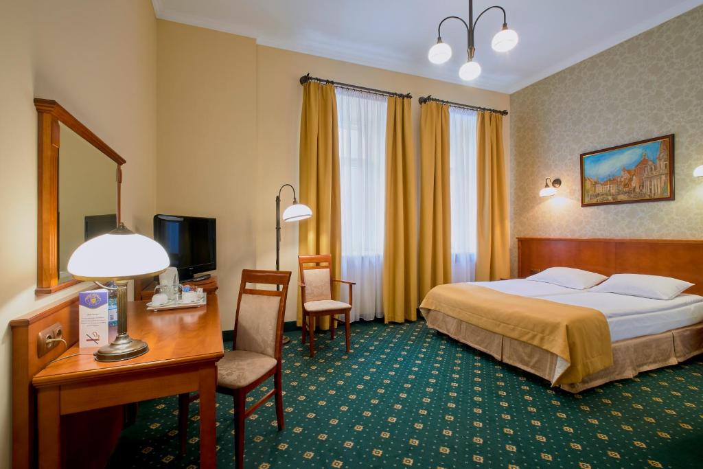 华沙恒曼酒店的酒店客房配有一张床、一张书桌和一台电脑