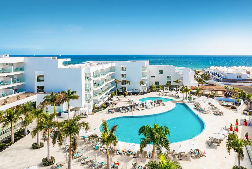 卡门港Hotel Lava Beach的享有带游泳池和海洋的度假村的空中景致