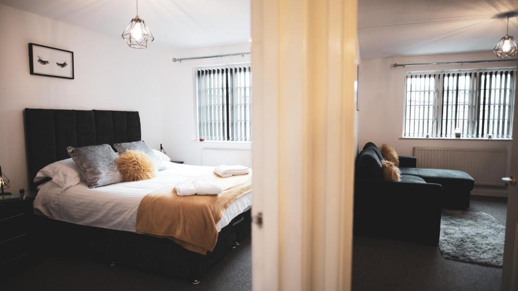 伍斯特Asha Court Serviced Apartments的一间卧室配有一张床和一张沙发
