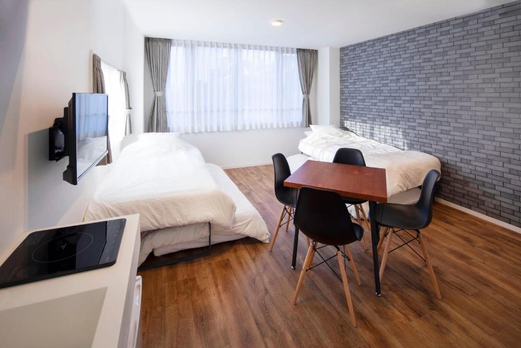 东京HOTEL LITTLE BIRD OKU-ASAKUSA / Vacation STAY 79448的卧室配有一张床和一张桌子及椅子