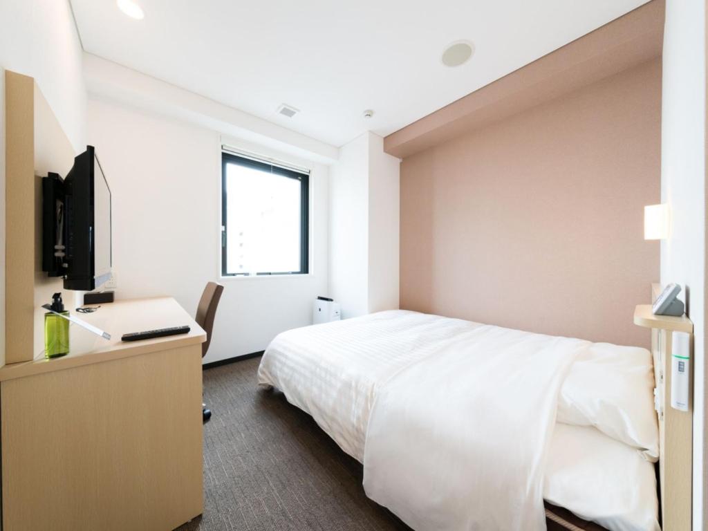 东京Super Hotel Tokyo Kinshicho Ekimae / Vacation STAY 79353的一间卧室配有一张床、一张书桌和一台电视