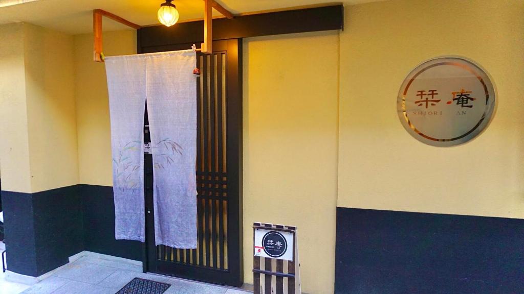 京都ゲストハウス栞庵的墙上有标志的建筑物的门