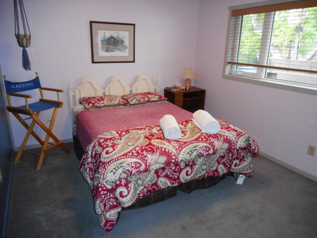 怀特霍斯Queen, walk to village center的一间卧室配有一张带红色被子和椅子的床