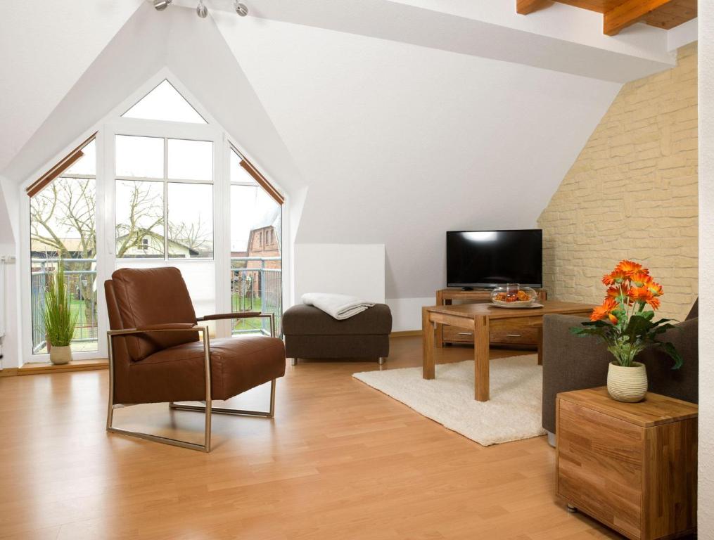 蒂门多夫Appartements Am Reiterhof Seepferdchen的客厅配有椅子和电视