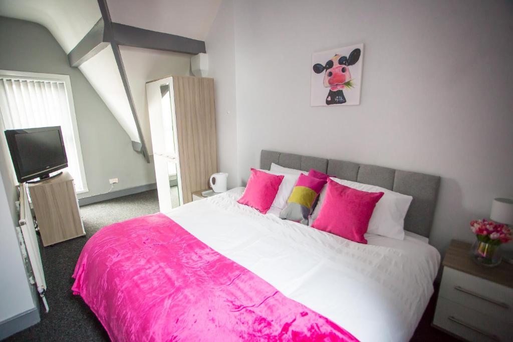 伯明翰Wray And Whyte House的卧室配有一张带粉红色枕头的大床