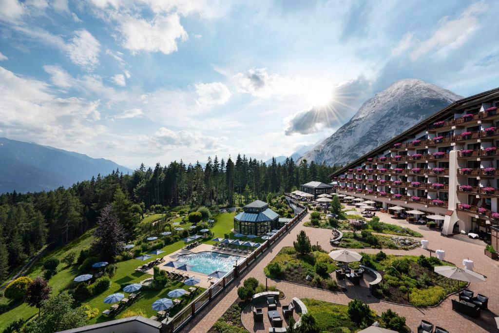 布肯Interalpen-Hotel Tyrol的享有带游泳池和山脉的度假村的空中景致