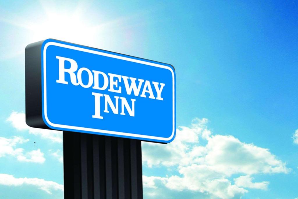PittsfieldRodeway Inn的蓝路极限标志,背面有太阳