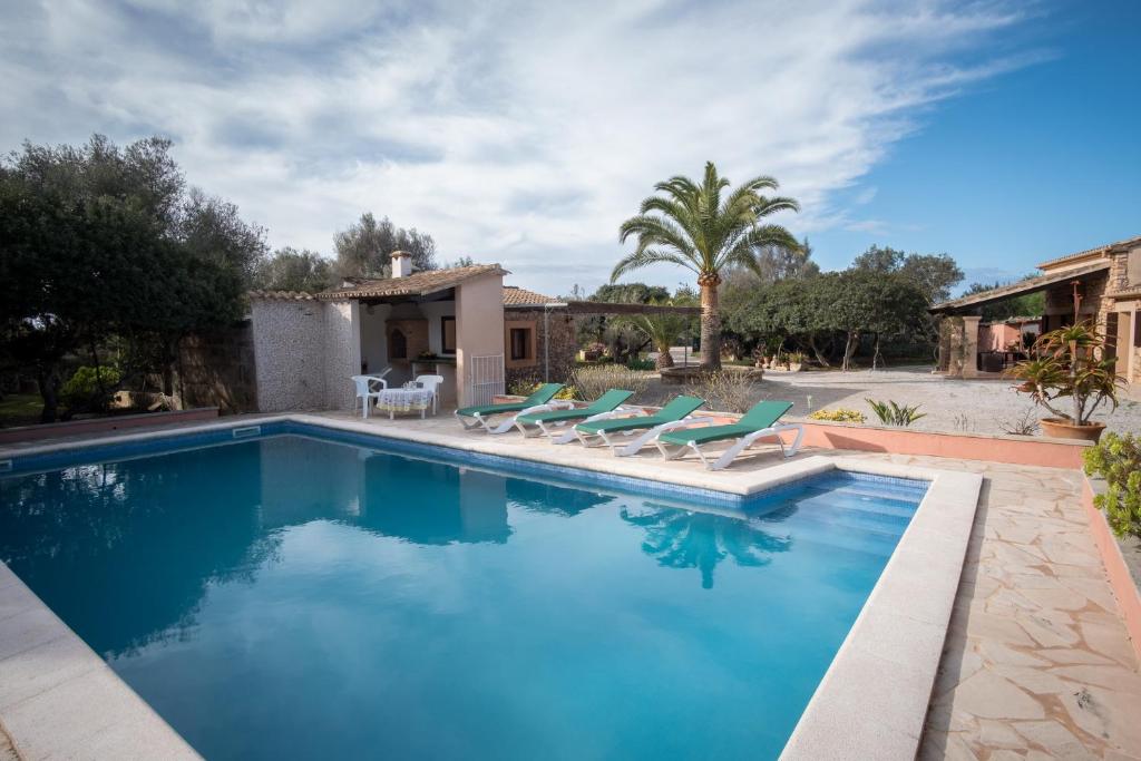 桑坦伊Sa Bassa Llova mit Pool und Wifi的一个带椅子的游泳池以及一座房子